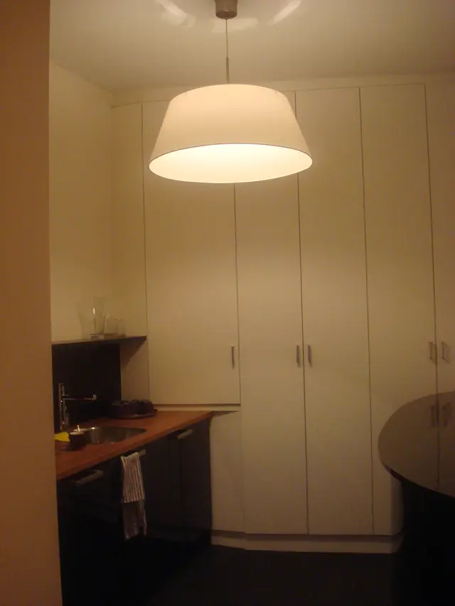 Witte inbouwkasten en keukenblad onder hanglamp