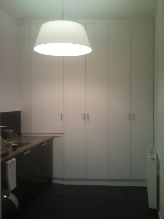 Witte inbouwkasten in keuken met radiator