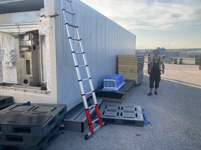 Aanbouw van de witte unit met staalwerk en ladder ertegenaan