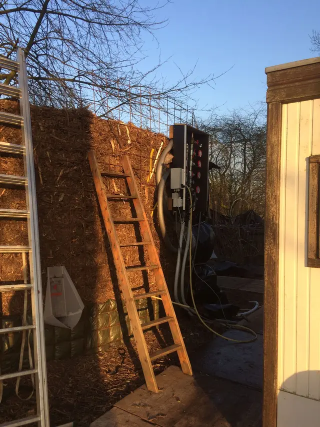 Houten ladder tegen de compostwand met technische kast
