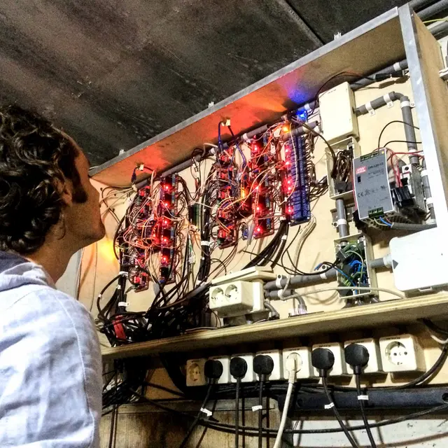 Elektricien inspecteert bekabeld domoticapaneel met relais
