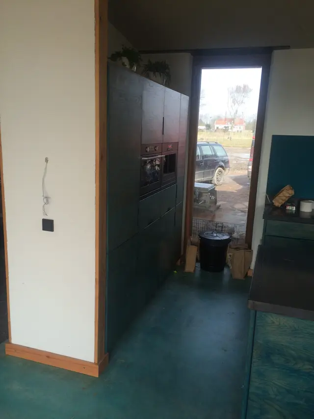 Kastenwand met inbouwovens in blauwe houten keuken