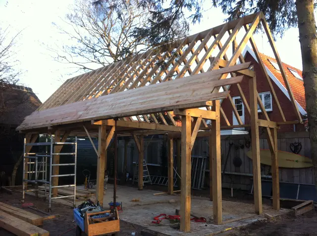 Eiken dakconstructie met dakbeschot van schuur in aanbouw