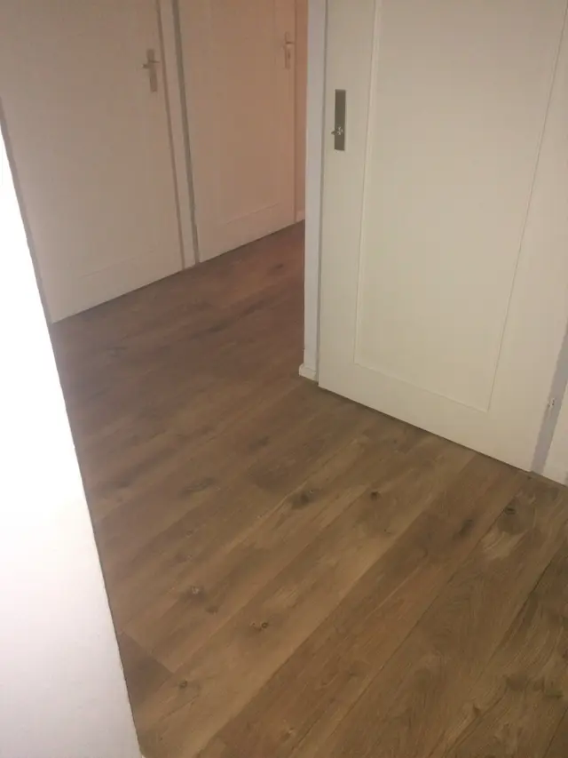 Eiken plankenvloer bij witte binnendeuren
