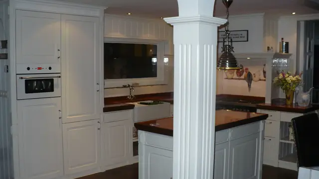 Witte keuken met sierzuil, fornuis en televisie