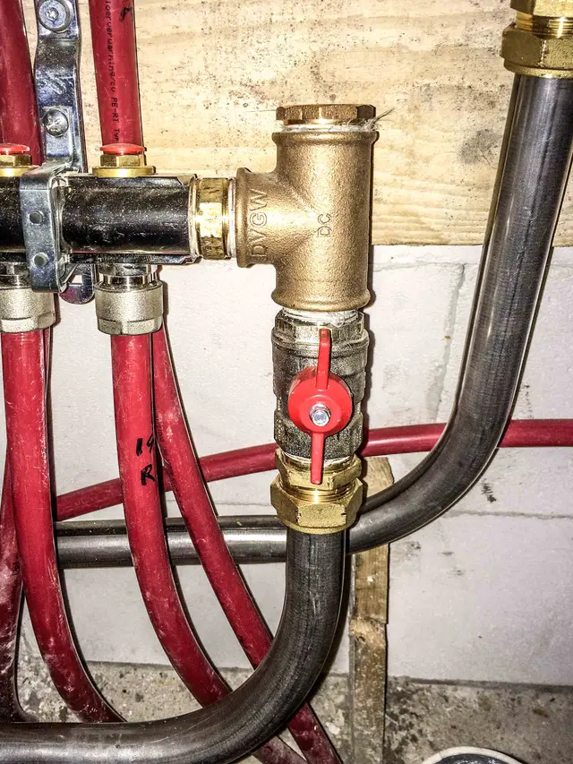 Koperen T-stuk met afsluiter in leidingwerk