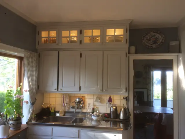 Witte keukenkasten met glas-in-lood deurtjes en spoelbak