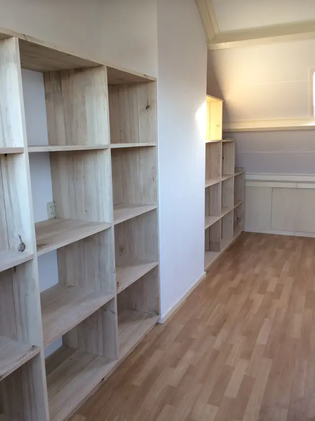 Kastanjehouten boekenkast tegen schuine zolderwand