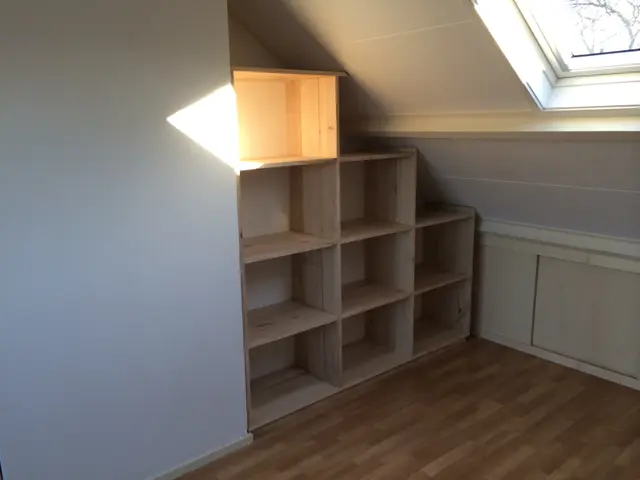 Kastanjehouten kast met open deurtje onder schuin dak