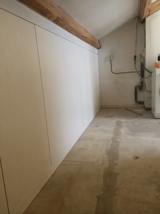 Witte knieschotkast tegen schuine zolderwand