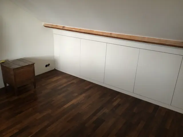 Knieschotkast met houten balk boven kastenwand