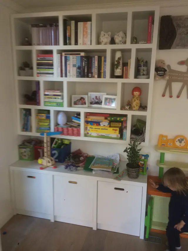 Ingebouwde boekenkast met opbergkasten in kinderkamer