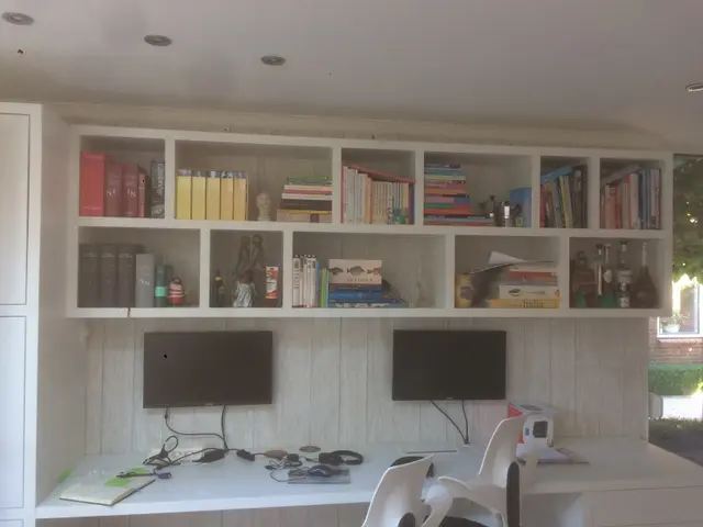 Wandkast met boeken boven een bureau