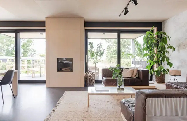 Woonkamer met houten schouw en lederen bank