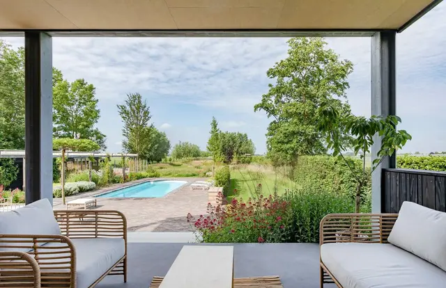 Loungeterras met rotan stoelen en zwembad