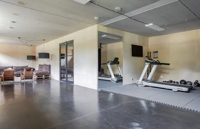 Fitnessruimte met bankstel en loopbanden