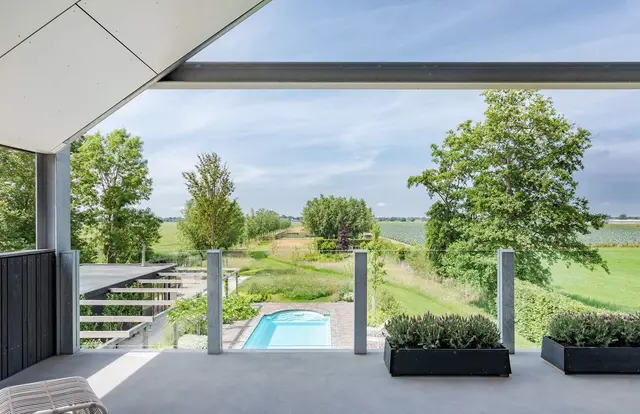 Overdekt terras met zicht op zwembad en weiland
