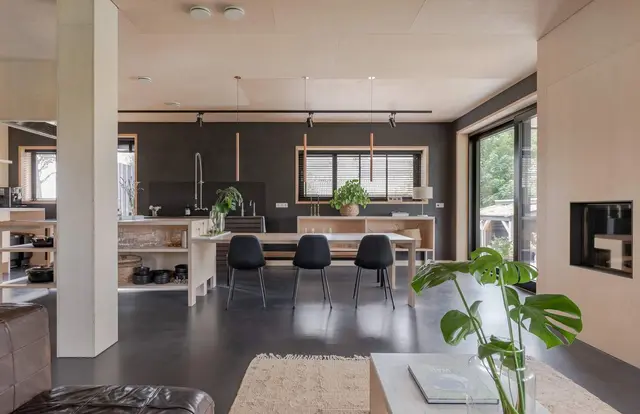 Open keuken en woonkamer met eettafel en haard