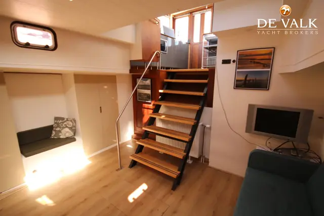 Houten trap naar kajuit met blauwe bank