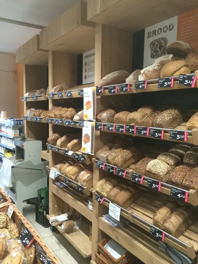 Broodschap met volle stellingen en snijmachine