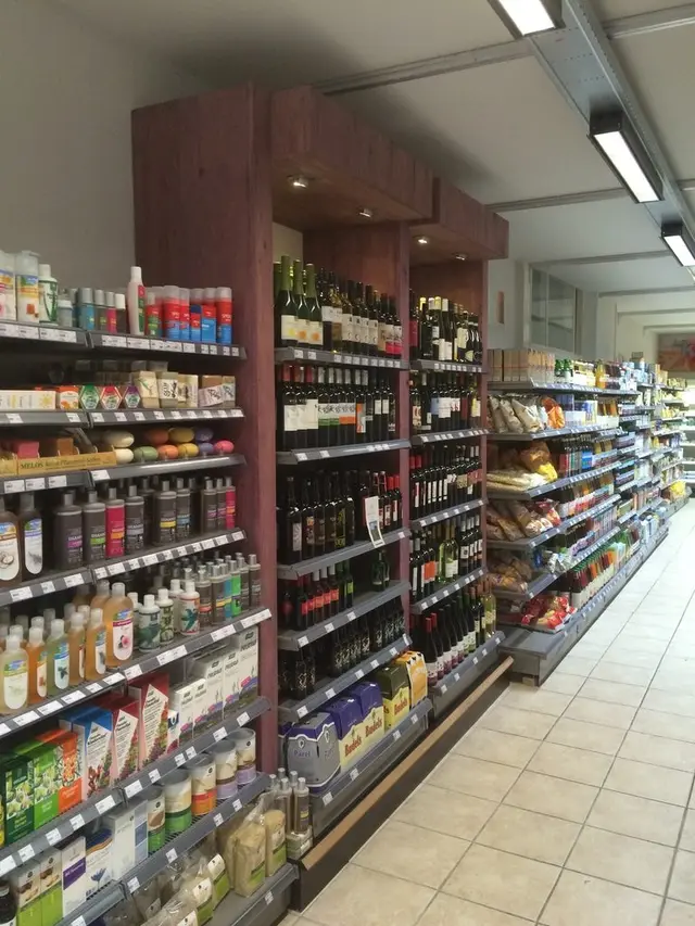 Wijn- en verzorgingsschappen tussen houten kolommen