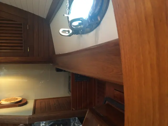 Salon met ronde patrijspoort en teakhouten betimmering