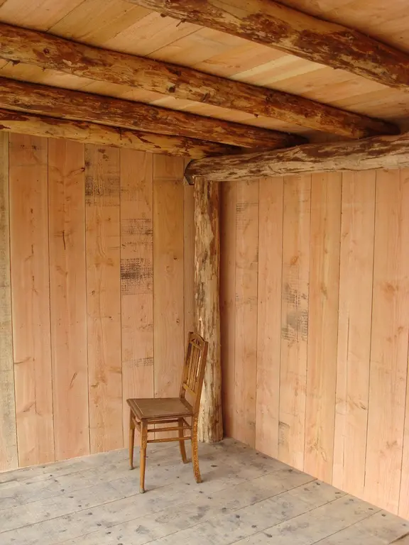 Lege houten veranda met stoel en boomstam-hoekpaal