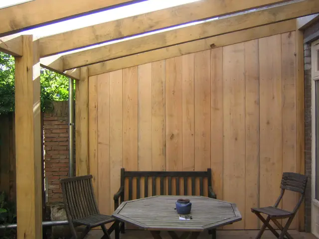 Overdekt terras met pergola, houten wand en zitplekken
